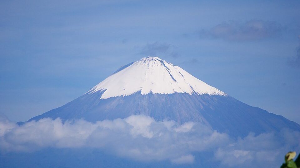 Fotografia do vulcão Sangay, no Equador, com o cone coberto de neve