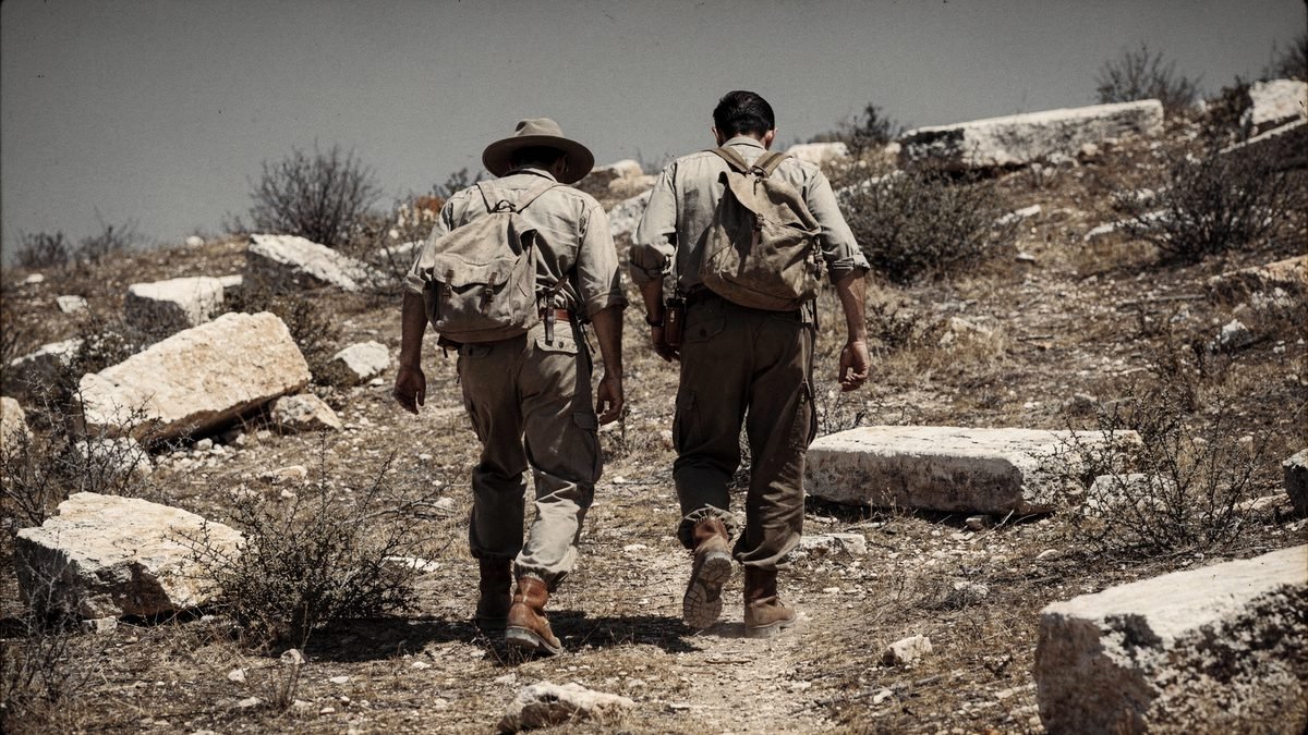 Re-creation of two researchers walking over a limestone hill in 1963