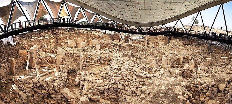 Photograph of an excavated enclosure at Göbekli Tepe, with T-shaped pillars between stone walls
